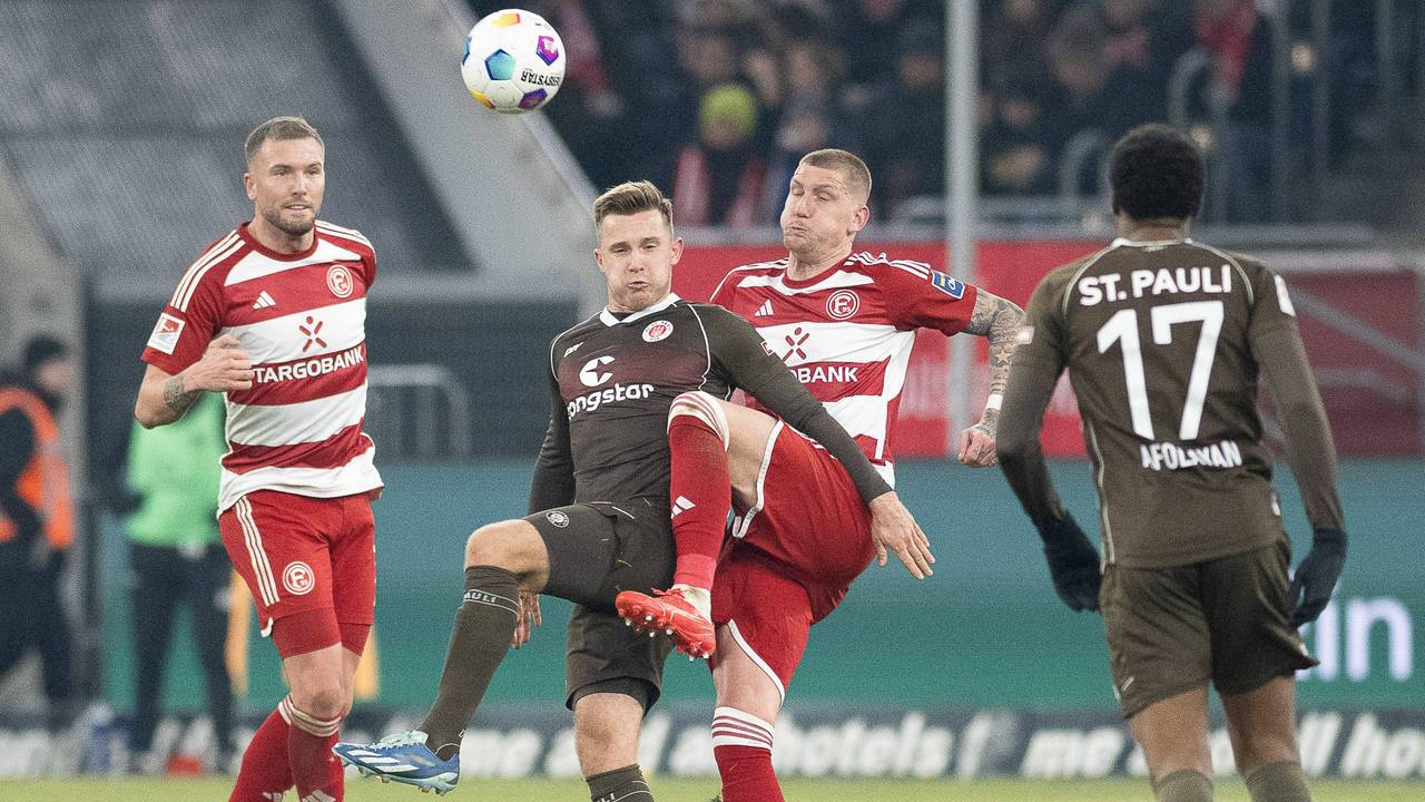 Die Düsseldorfer Innenverteidiger Andre Hoffmann und Jordy de Wijs versuchen, den Ball gegen St. Paulis Johannes Eggestein zu klären.