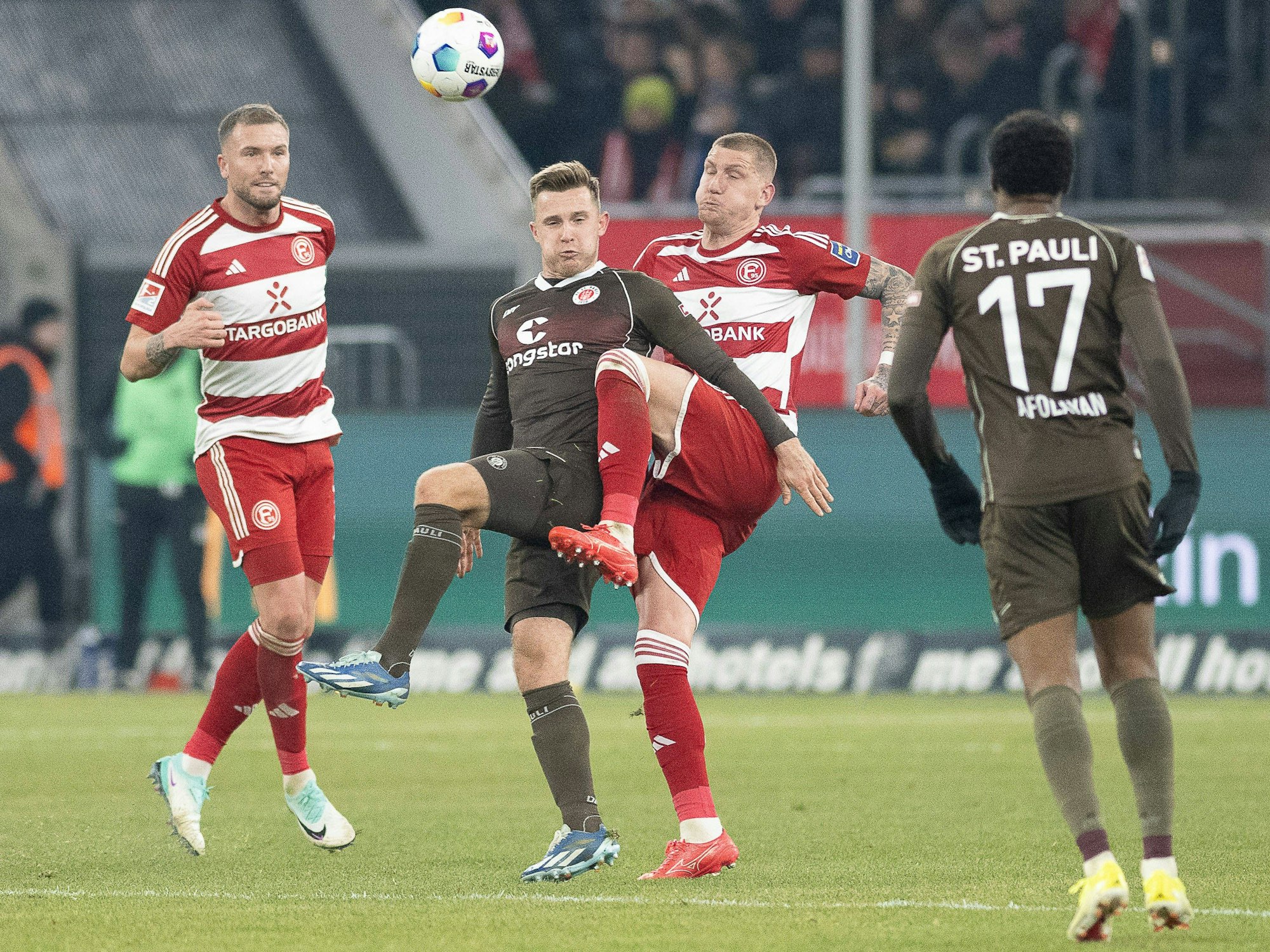Die Düsseldorfer Innenverteidiger Andre Hoffmann und Jordy de Wijs versuchen, den Ball gegen St. Paulis Johannes Eggestein zu klären.