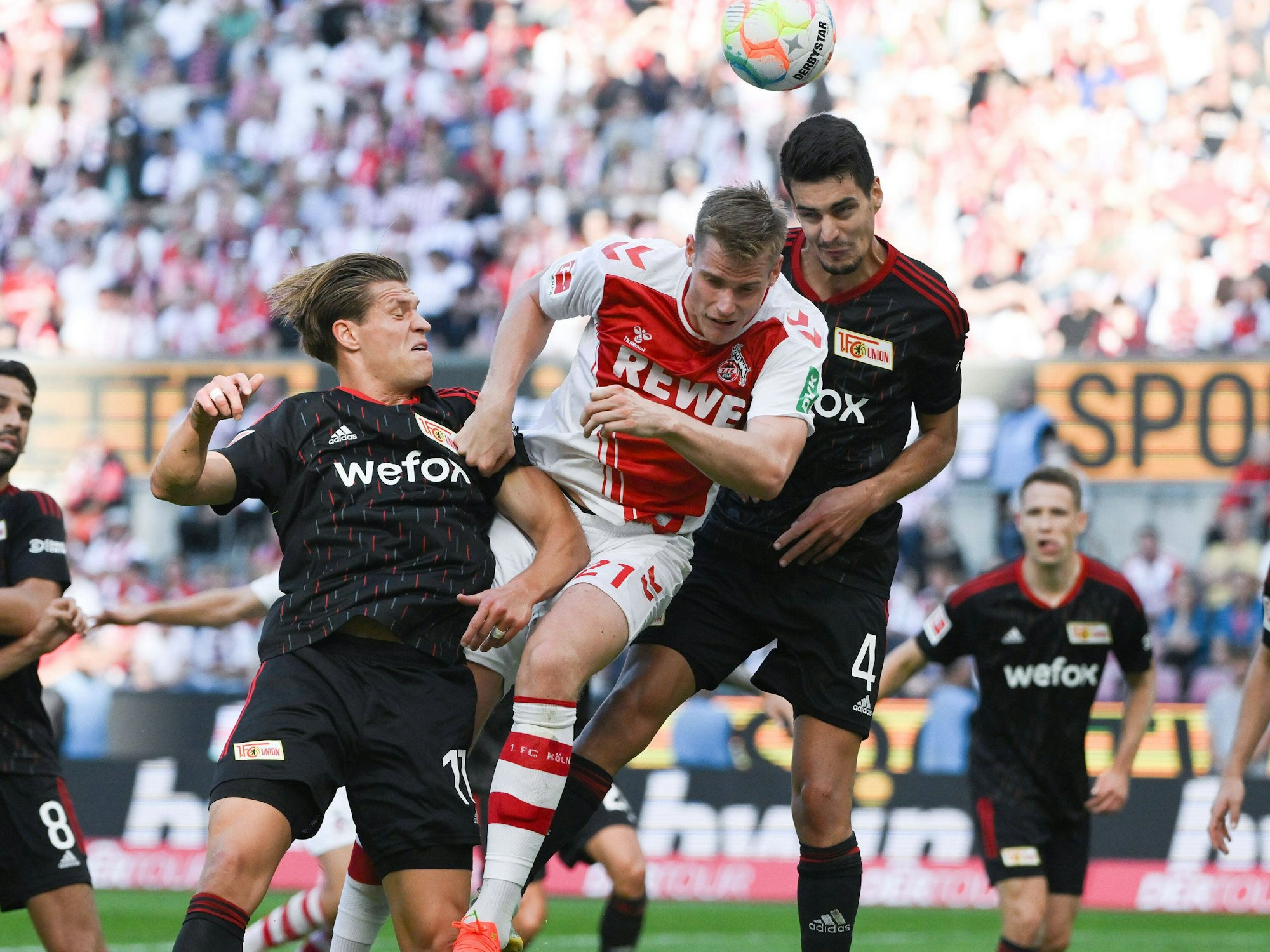 Steffen Tigges geht gegen Diogo Leite ins Kopfballduell. Kevin Behrens steigt ebenfalls hoch.