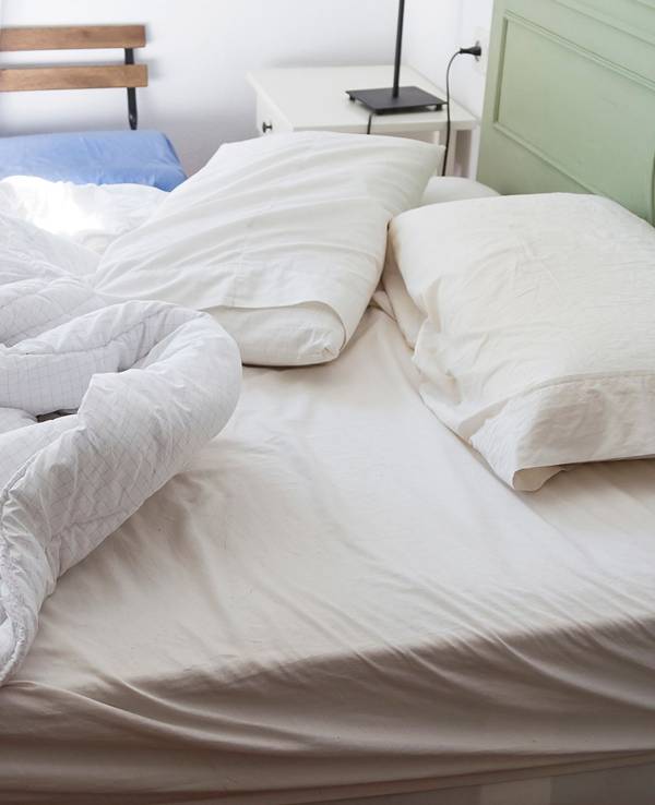 Auf dem Foto sieht man ein ungemachtes Bett.