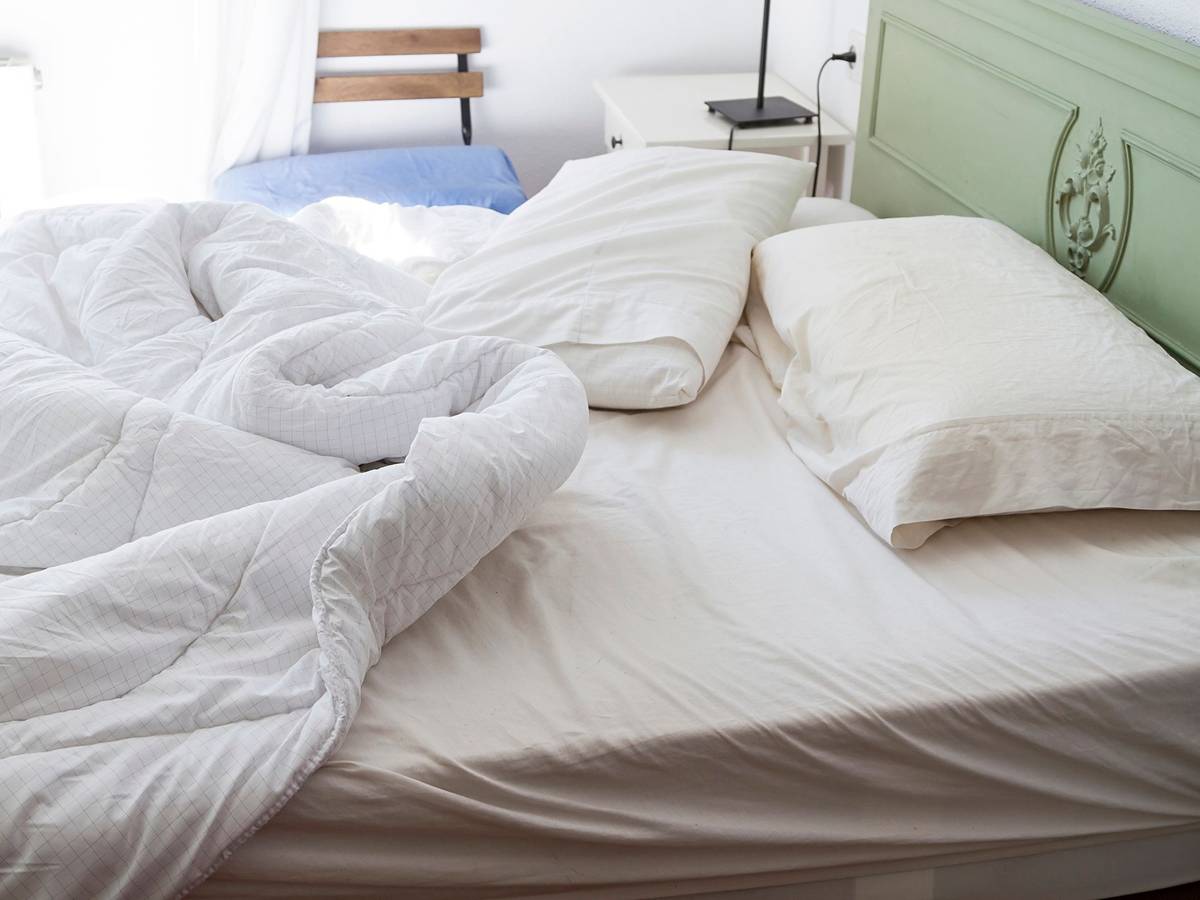 Auf dem Foto sieht man ein ungemachtes Bett.