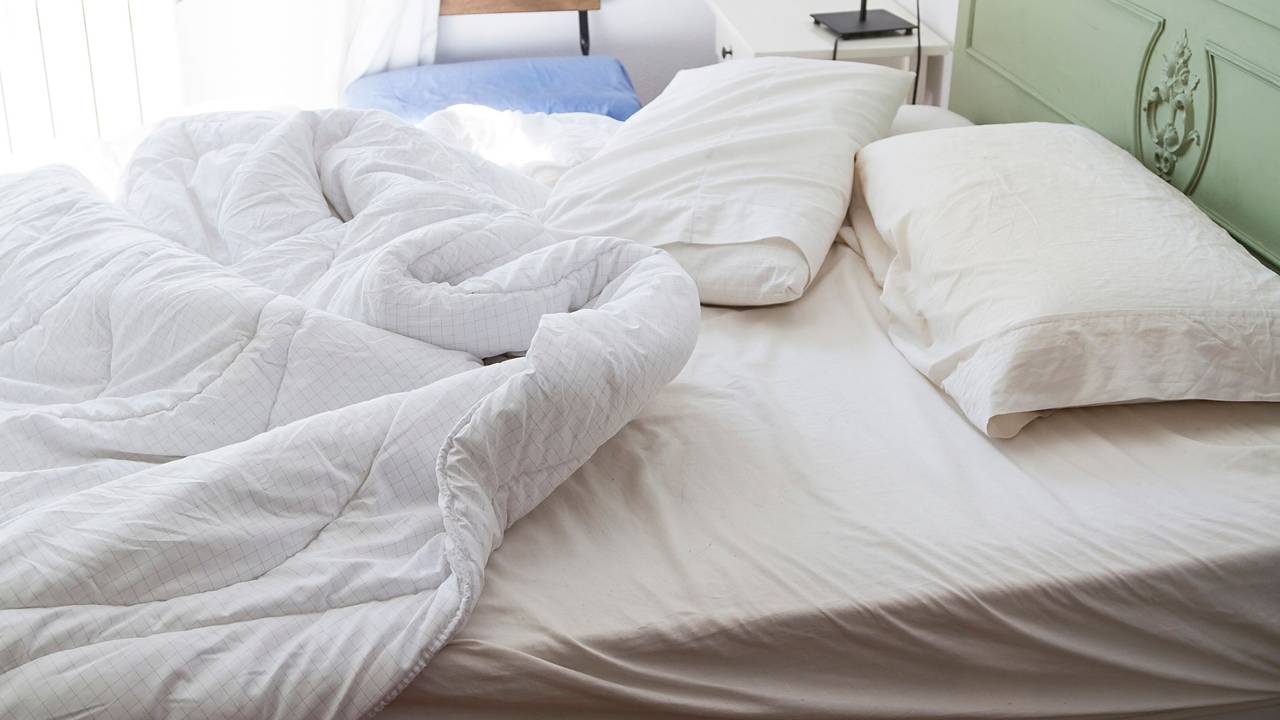 Auf dem Foto sieht man ein ungemachtes Bett.
