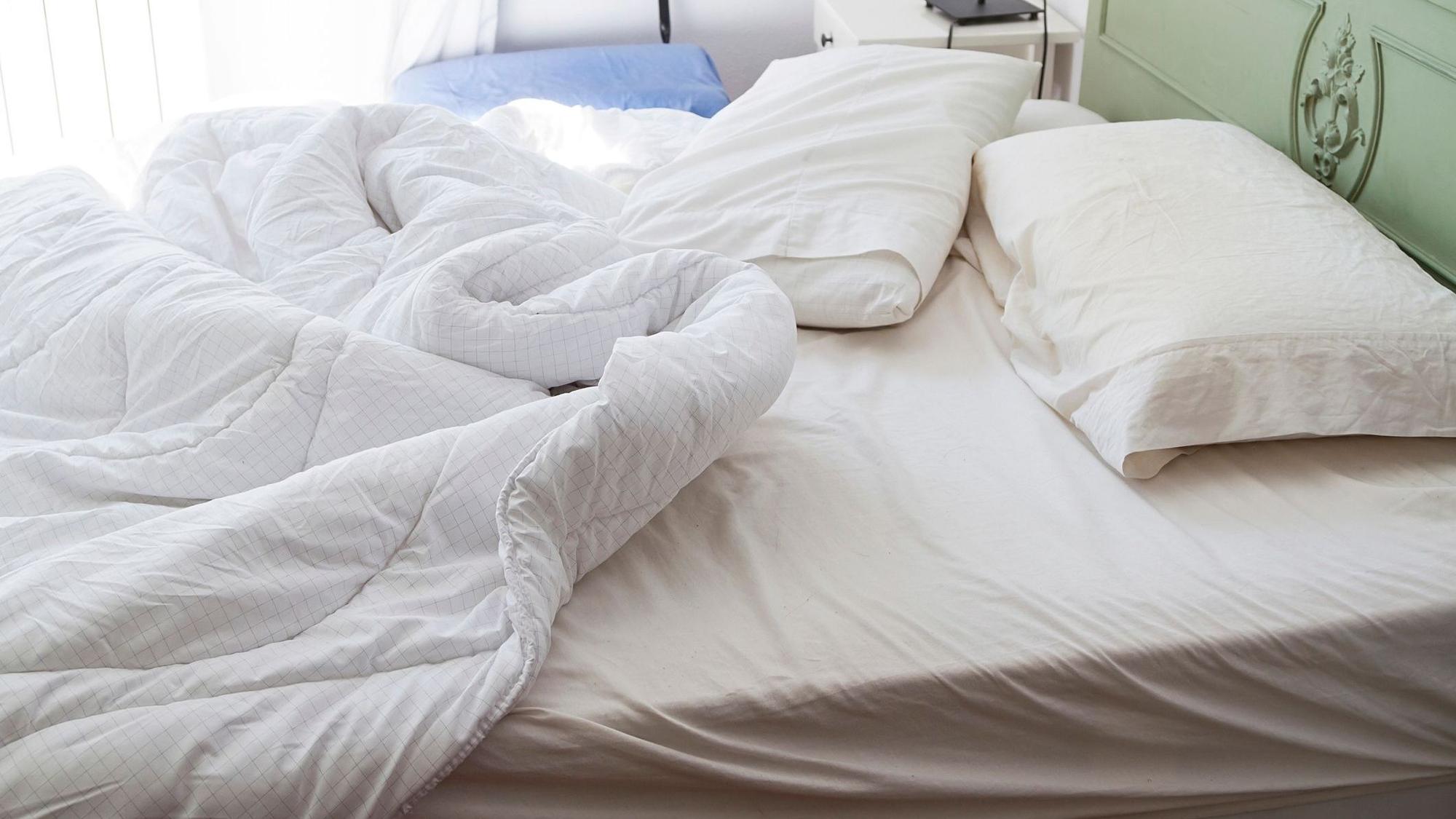 Auf dem Foto sieht man ein ungemachtes Bett.