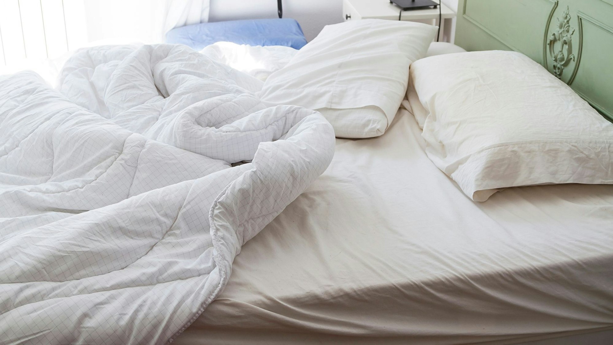 Auf dem Foto sieht man ein ungemachtes Bett.