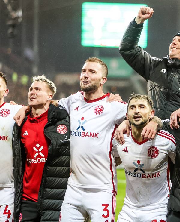 Spieler und Mitarbeiter von Fortuna Düsseldorf jubeln gemeinsam nach dem Sieg im Pokal-Spiel beim FC St. Pauli.