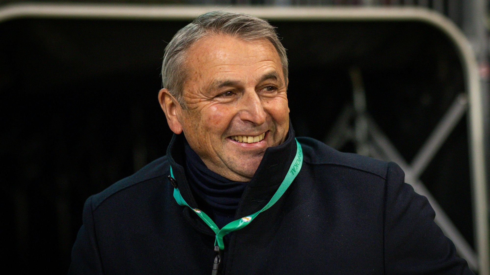 Fortuna Düsseldorfs Sport-Vorstand Klaus Allofs steht beim Pokal-Spiel beim FC St. Pauli lächelnd im Stadion.