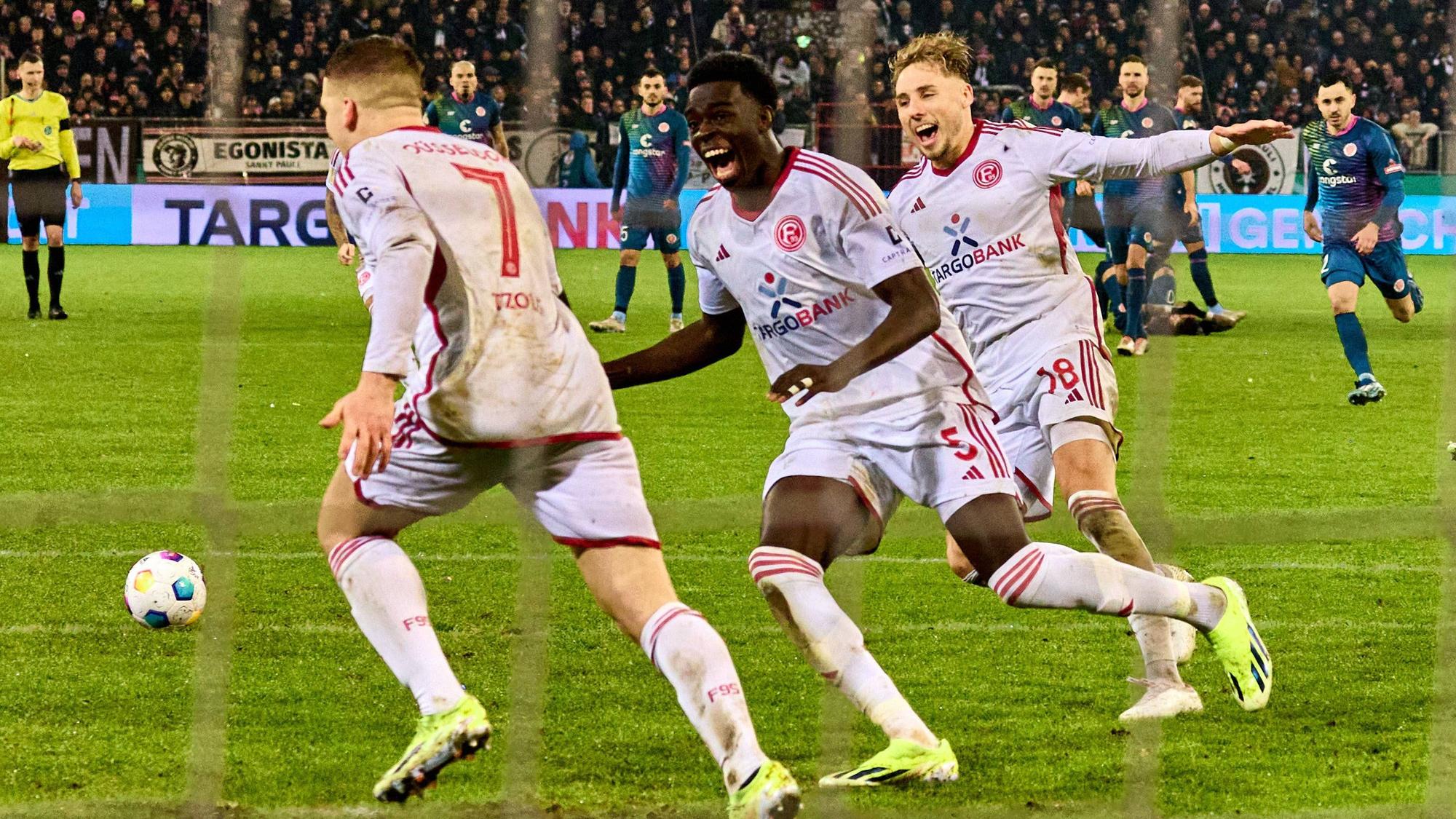 Fortuna Düsseldorf feiert Elfmeter-Held Christos Tzolis nach seinem entscheidenden Versuch im Spiel beim FC St. Pauli.