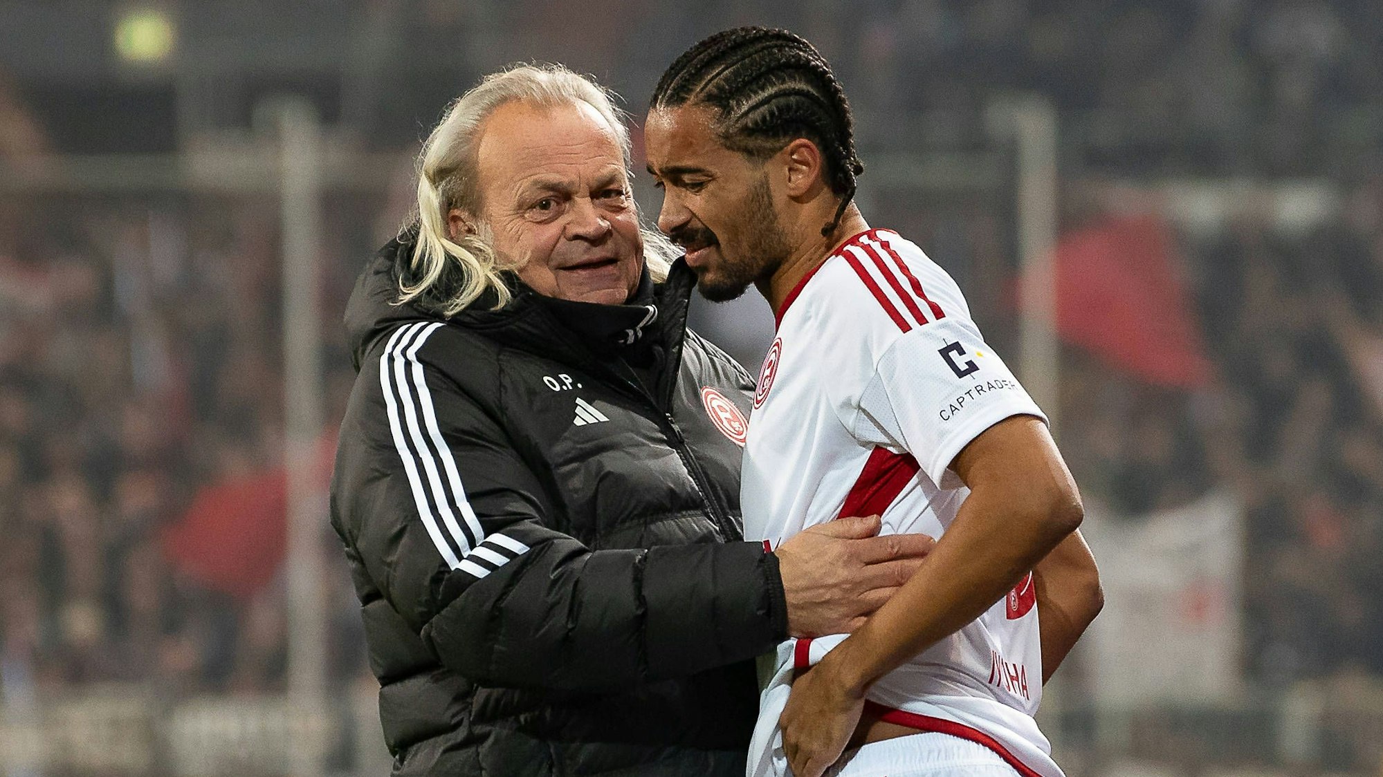 Fortuna Düsseldorfs Team-Arzt Ulf Blecker nimmt den verletzten Emmanuel Iyoha in den Arm.