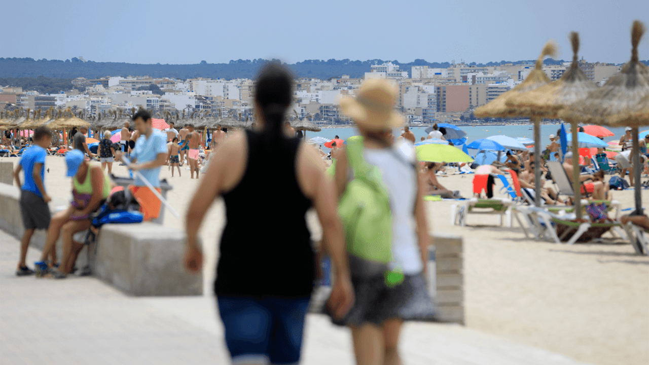 Urlauberinnen und Urlauber am Strand von Arenal auf Mallorca.
