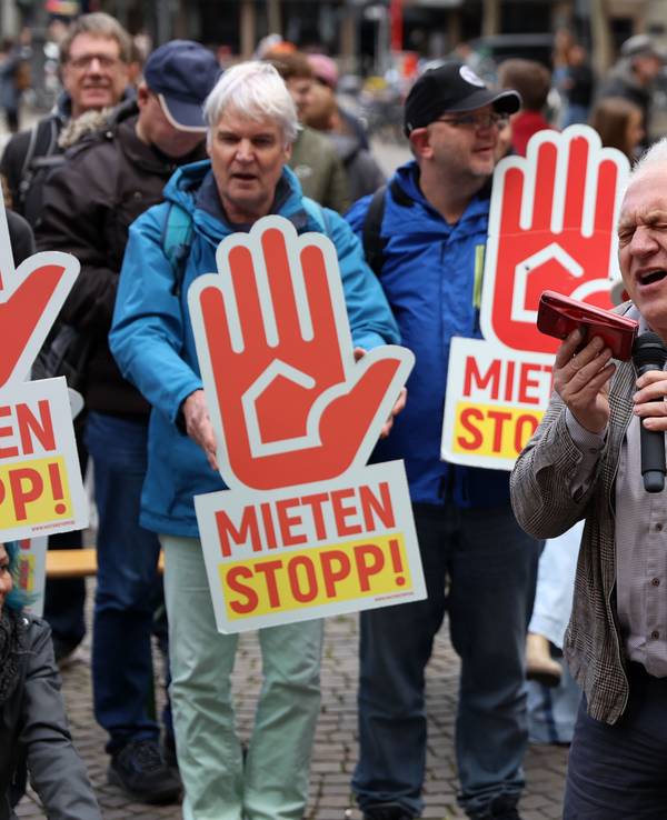 Ein Mann singt bei einer Demo vor Publikum.