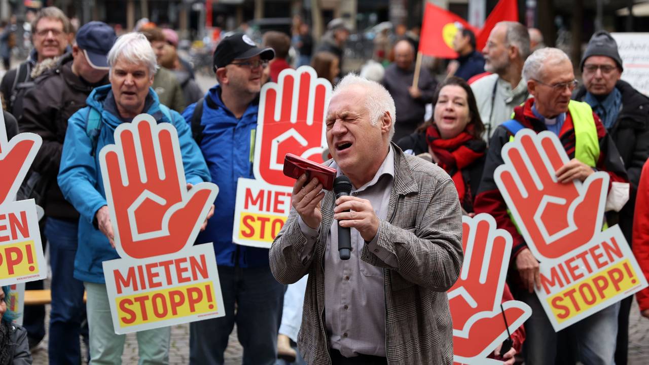 Ein Mann singt bei einer Demo vor Publikum.