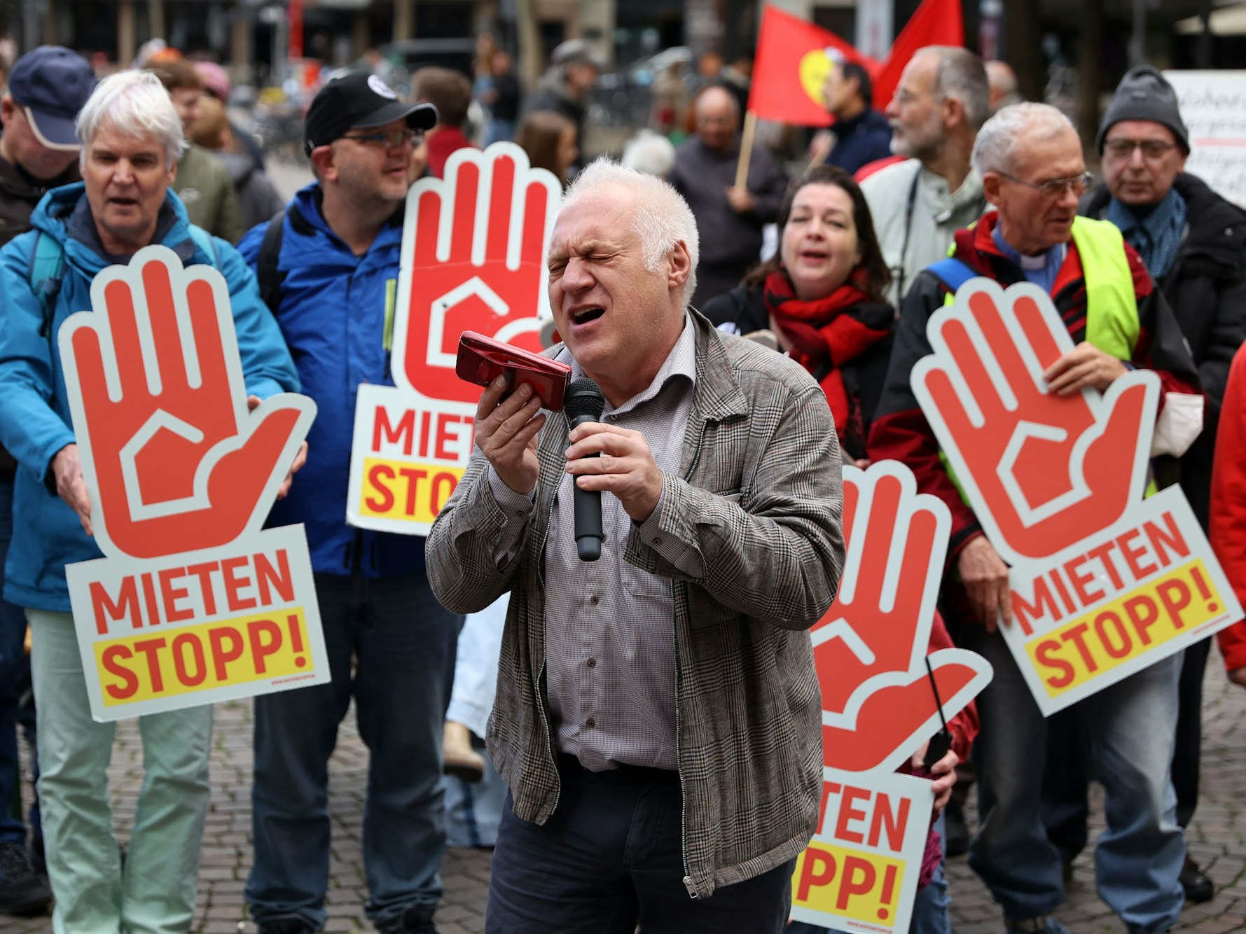 Ein Mann singt bei einer Demo vor Publikum.