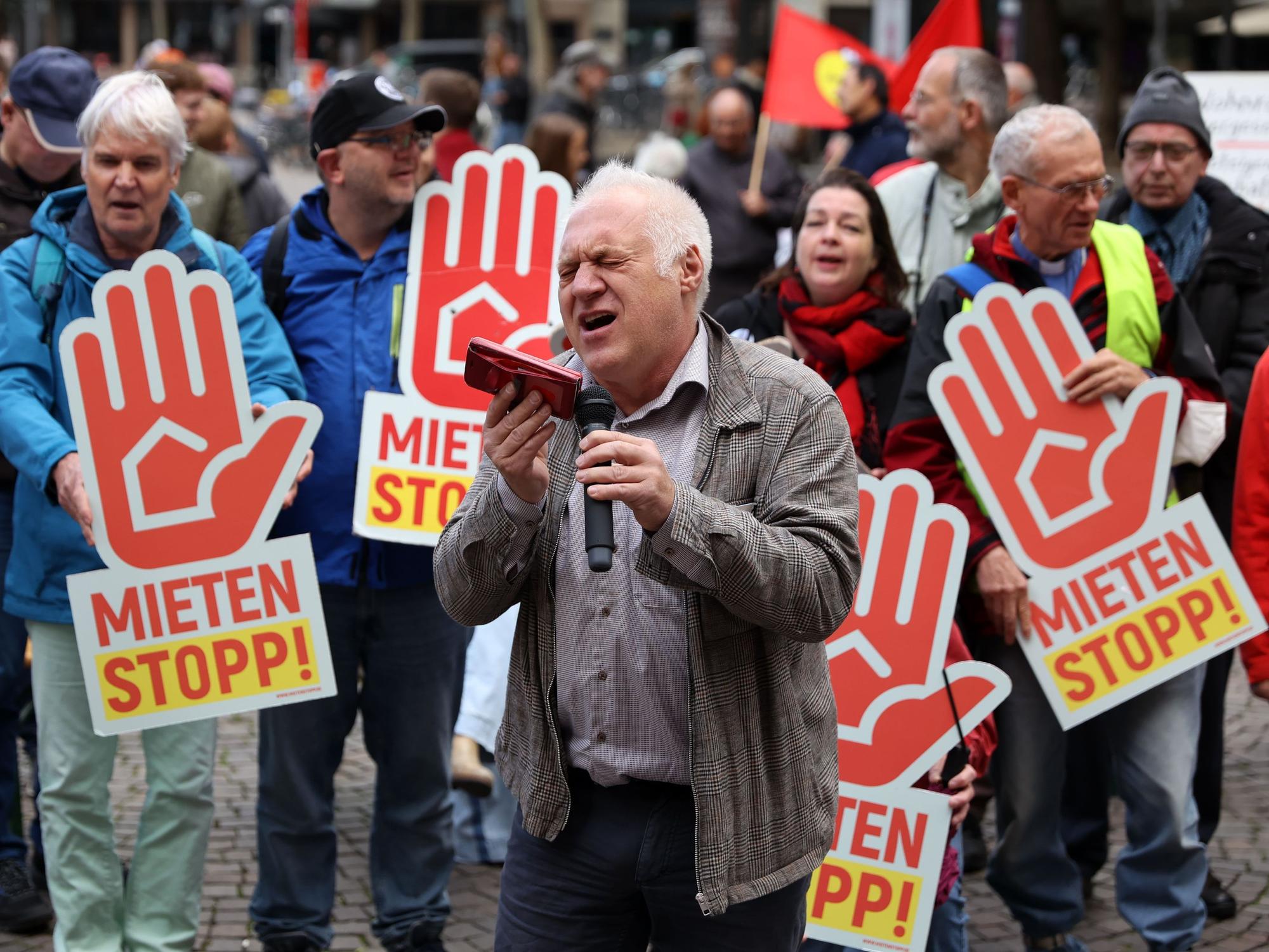Ein Mann singt bei einer Demo vor Publikum.