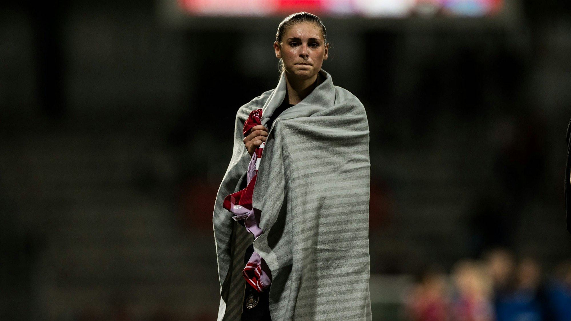 Jule Brand steht nach Spielschluss in eine Decke gehüllt im Stadion.