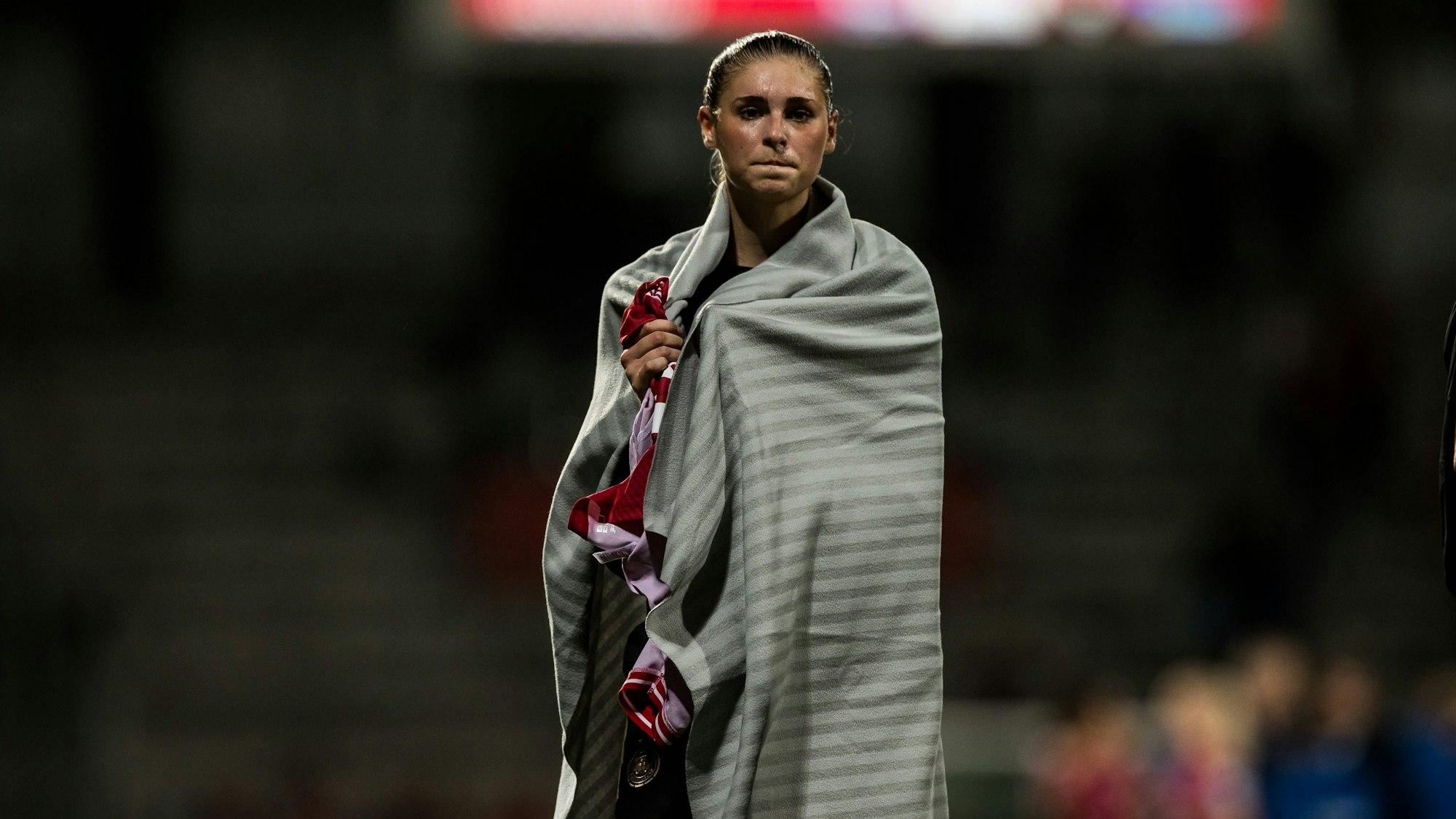 Jule Brand steht nach Spielschluss in eine Decke gehüllt im Stadion.