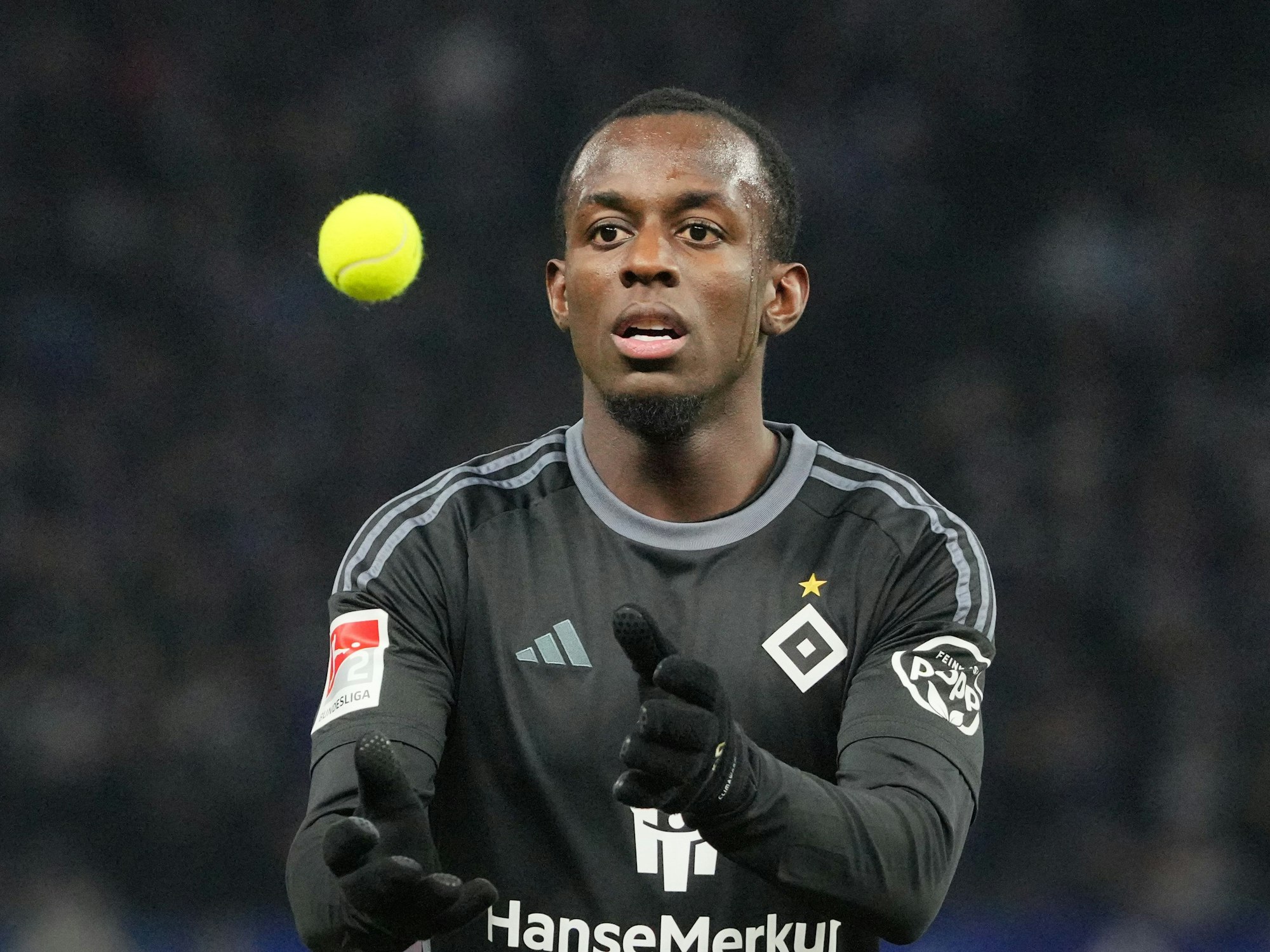 Jean-Luc Dompe vom HSV fängt einen der Tennisbälle, die von den Hertha-Fans aufs Spielfeld geworfen wurden.