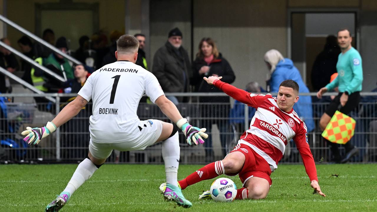 Fortuna Düsseldorfs Christos Tzolis grätscht nach dem Ball, Paderborns Keeper Pelle Boevik versucht zu parieren.