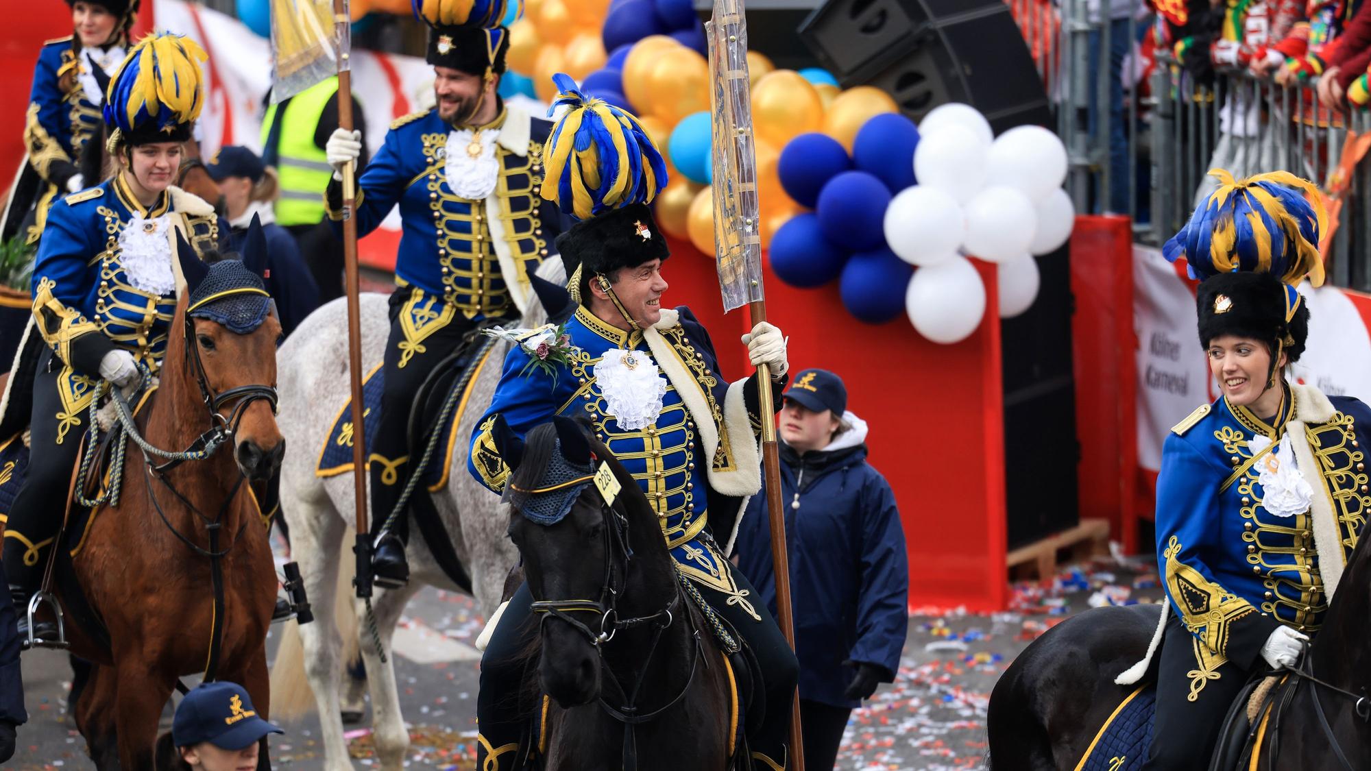 Reiter auf Pferden laufen im Festumzug mit.
