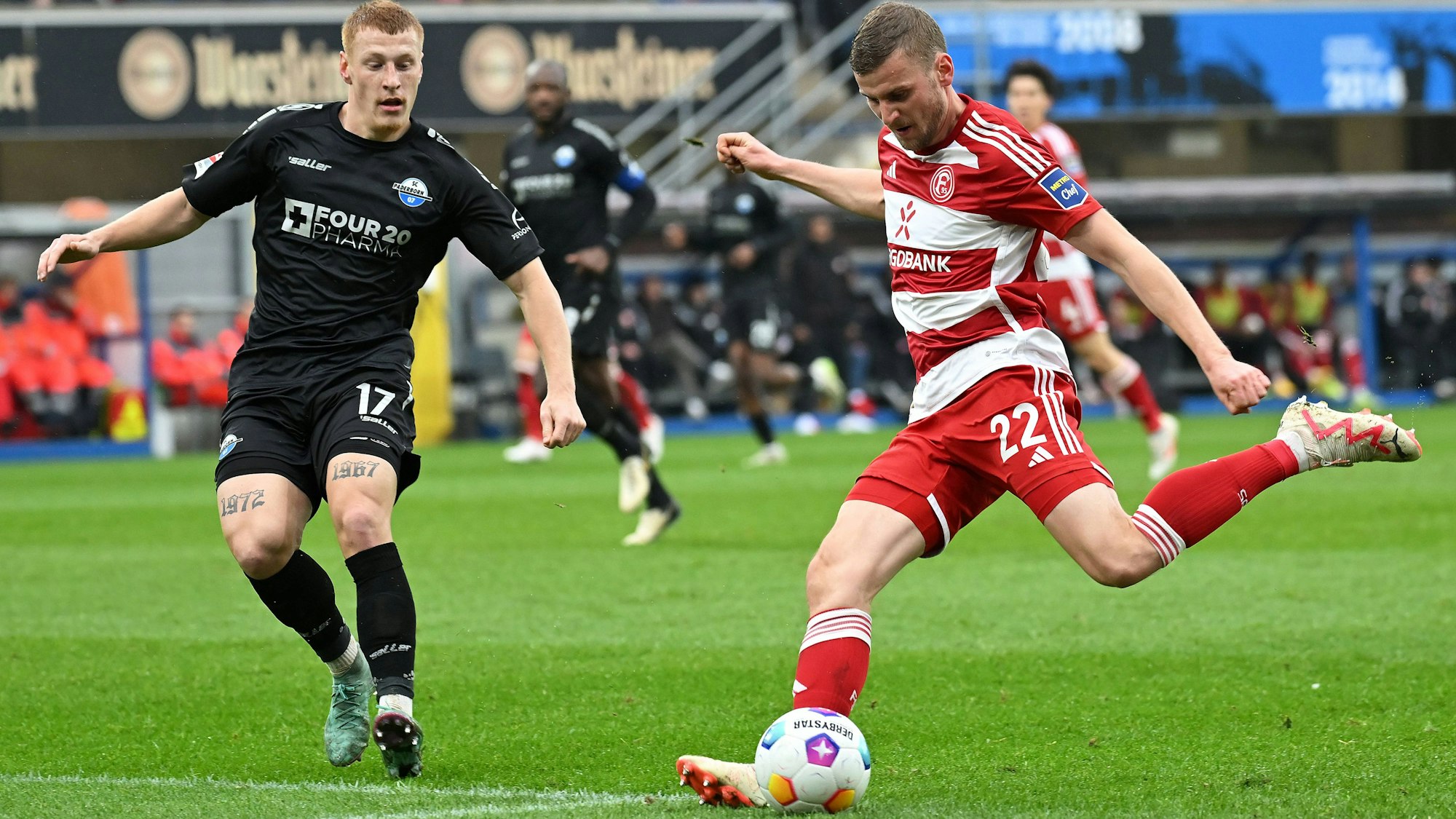 Fortuna Düsseldorfs Christoph Daferner schießt, Paderborns Laurin Curda versucht, das zu verhindern.