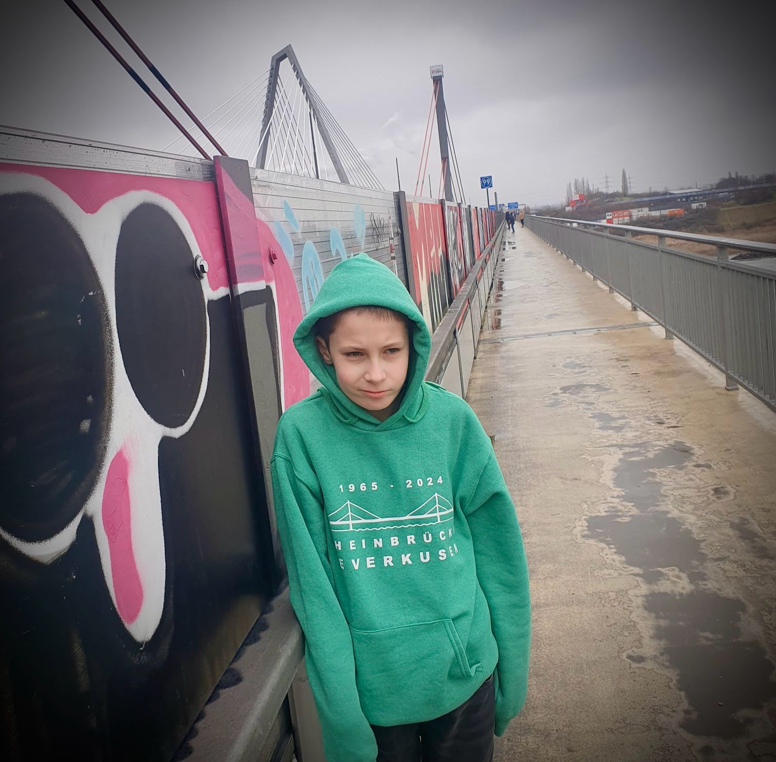 Connor steht auf dem Fußweg der Leverkusener Brücke.