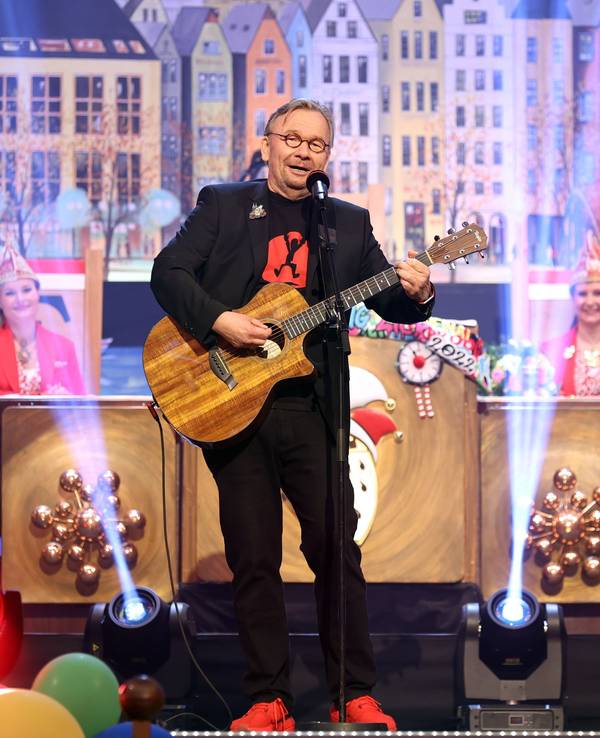 Bernd Stelter auf einer Karnevalssitzung mit Gitarre in der Hand auf der Bühne.