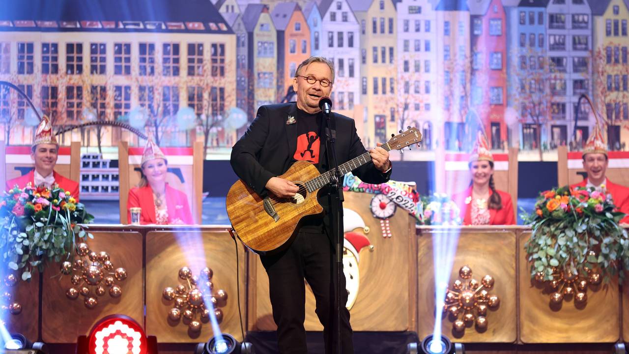 Bernd Stelter auf einer Karnevalssitzung mit Gitarre in der Hand auf der Bühne.