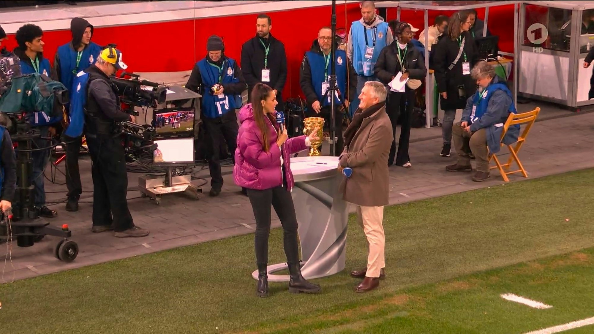 Bastian Schweinsteiger und Esther Sedlaczek stehen bei der ARD-Übertragung zum DFB-Pokal zwischen Bayer Leverkusen und dem VfB Stuttgart am TV-Tisch.