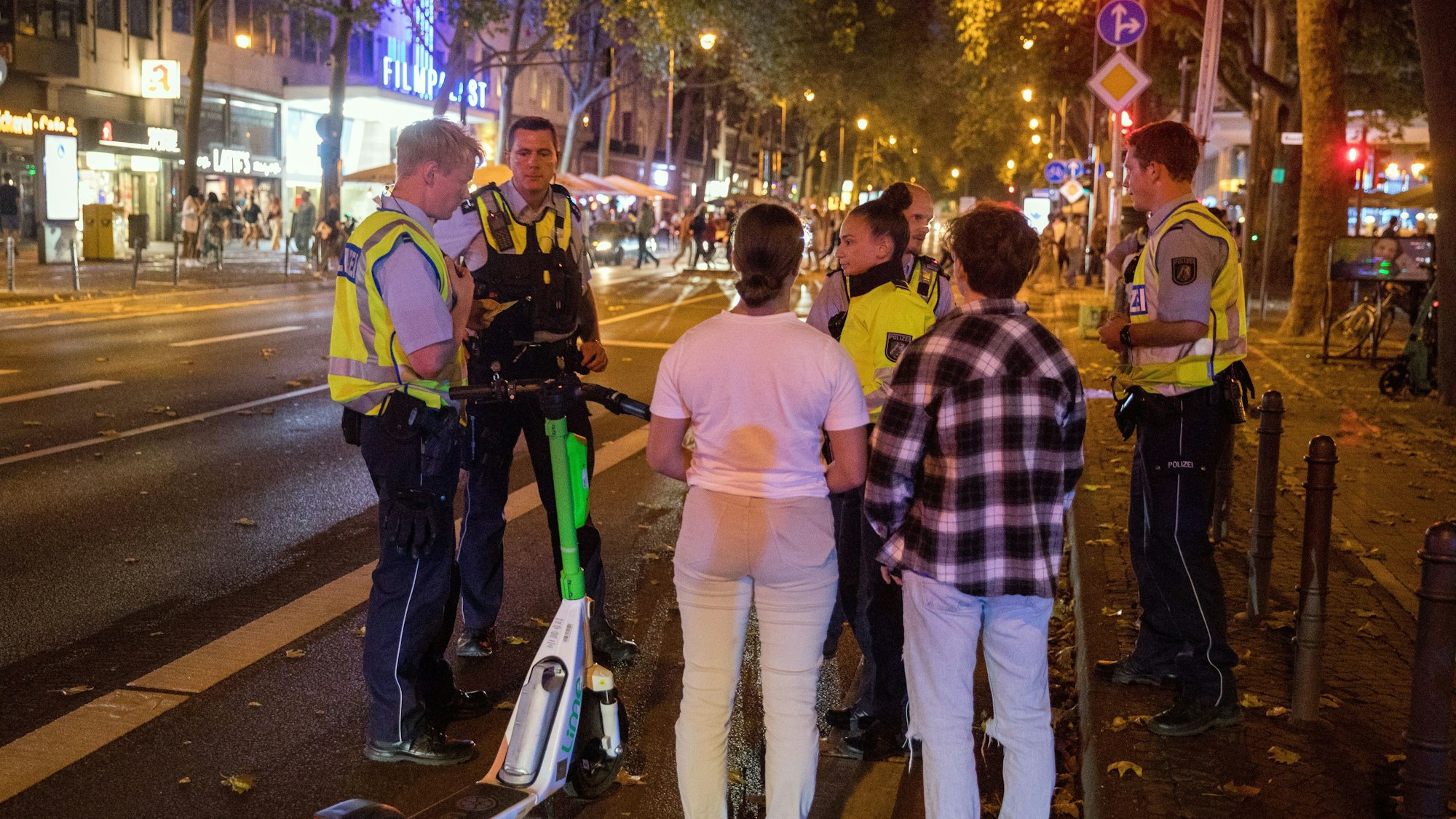 Mehrere Polizisten kontrollieren E-Scooter-Nutzer auf de Hohenzollernring in Köln.