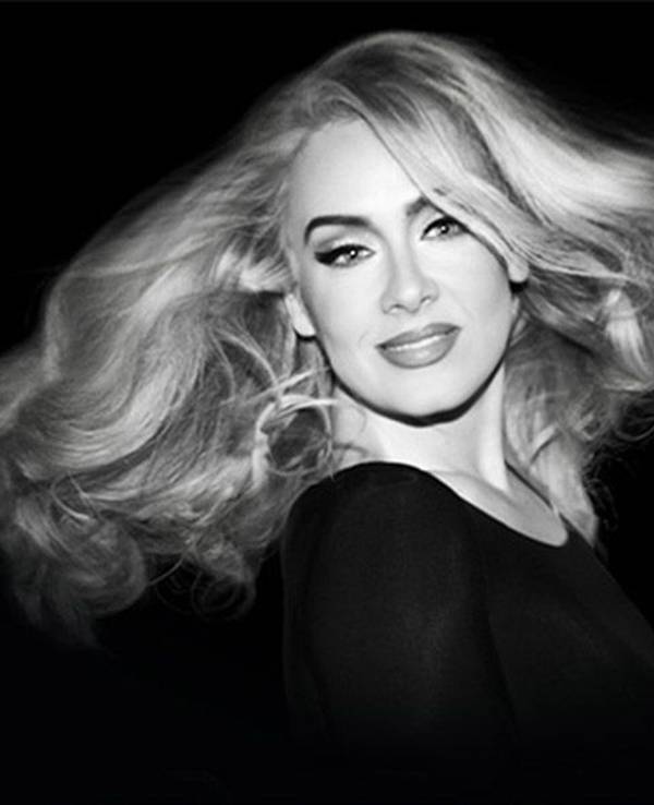 Adele in Schwarz-Weiß lächelt in die Kamera.