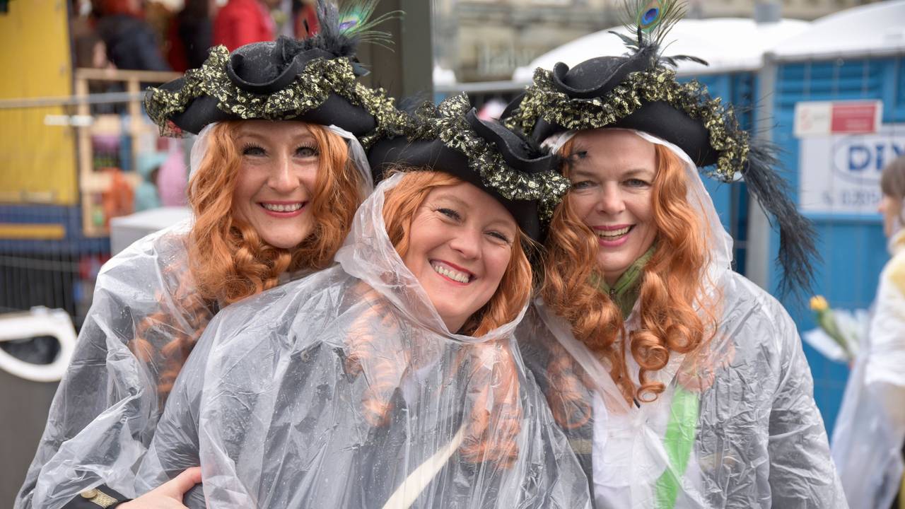 Drei Jecke mit Regenponchos am Neumarkt in Köln