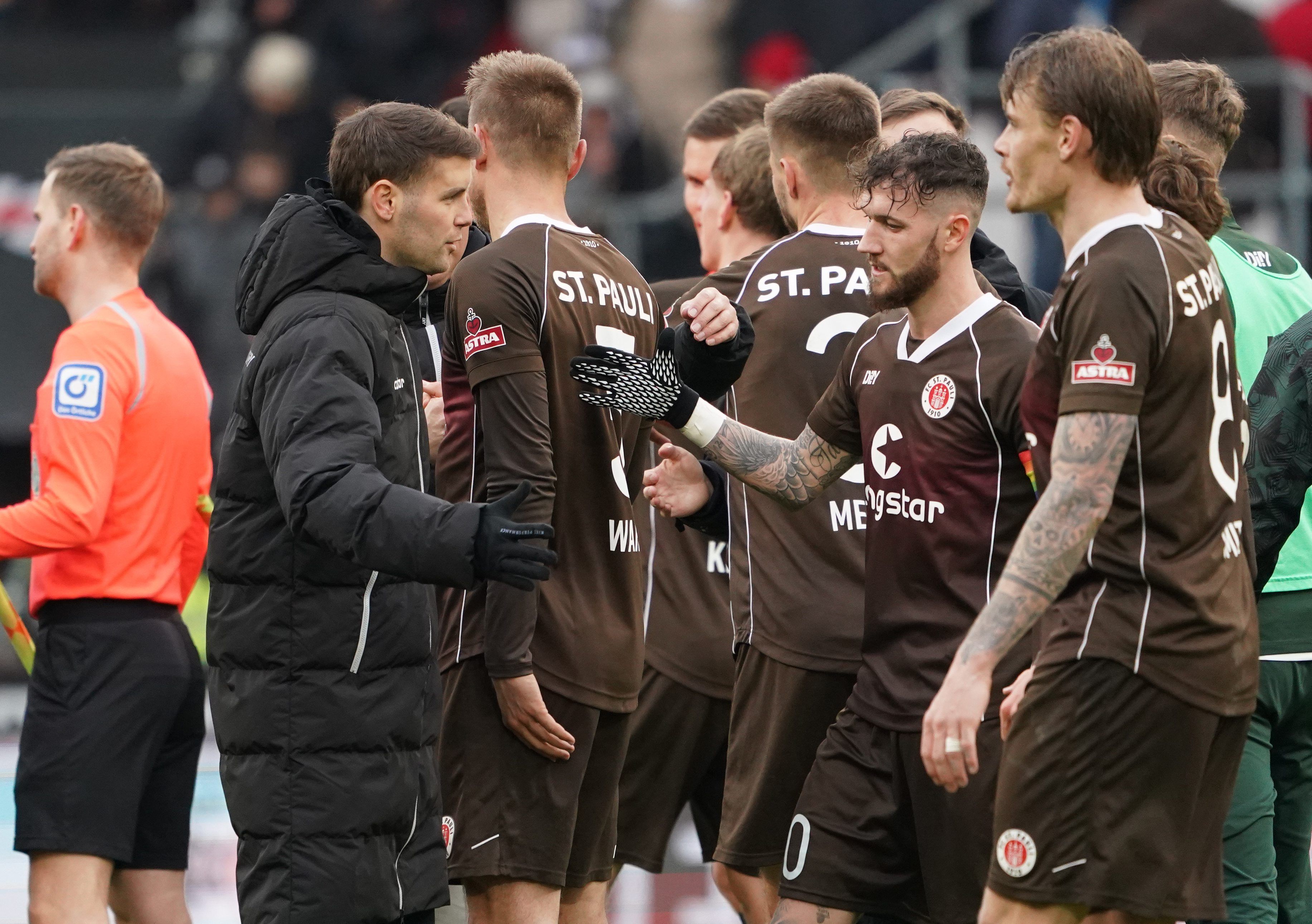 St. Paulis Trainer Fabian Hürzeler (M) jubelt mit seinen Spielern nach dem Sieg.