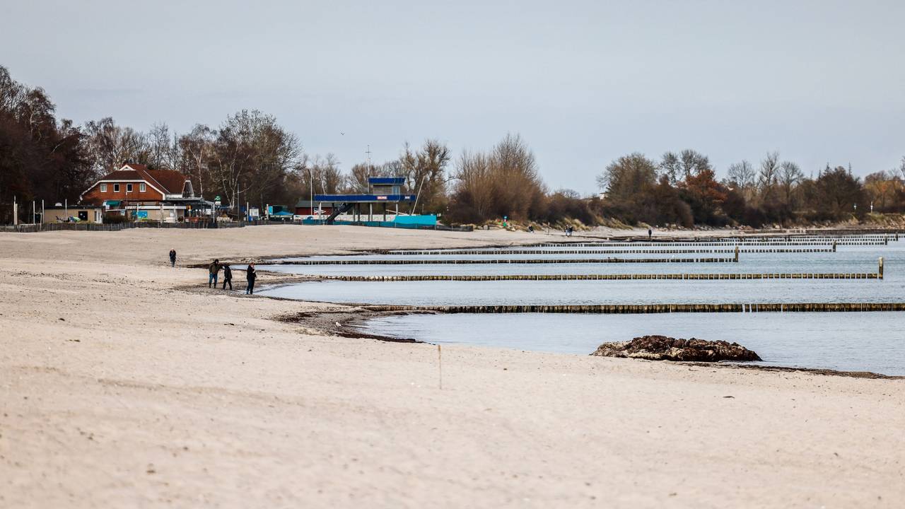 Personen am Starnd im Ostseebad Kellenhusen spazieren, hier im März 2022.
