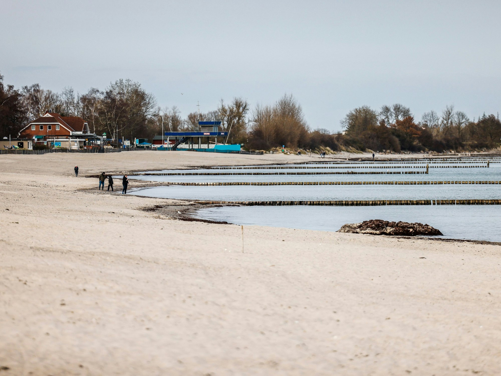 Personen am Starnd im Ostseebad Kellenhusen spazieren, hier im März 2022.