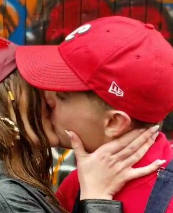Eine junge Frau und ein junger Mann geben sich einen Kuss.