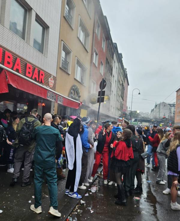 Menschen feiern vor einer Bar auf der Zülpicher Straße.