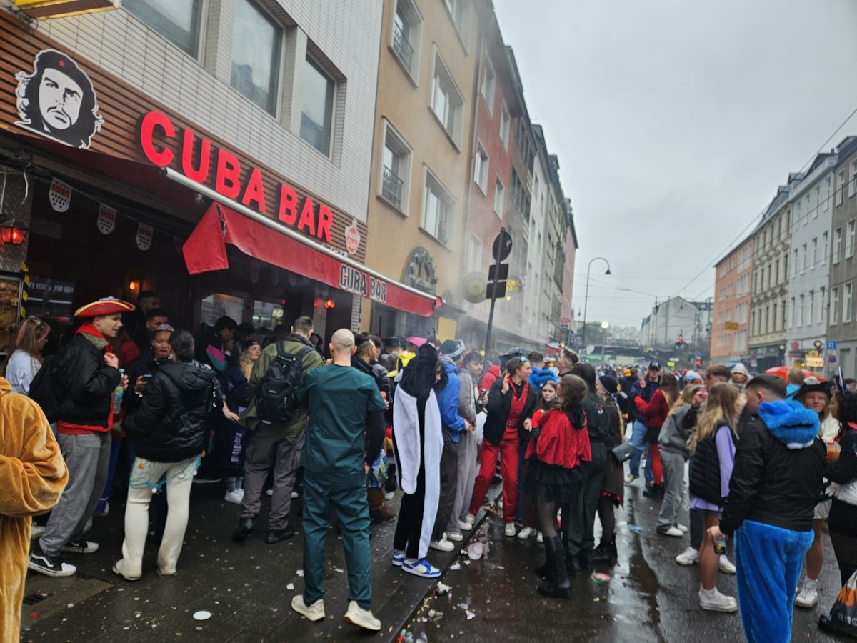 Menschen feiern vor einer Bar auf der Zülpicher Straße.