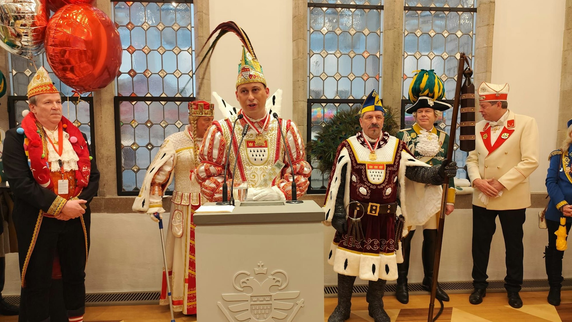Das Dreigestirn an einem Pult im Kölner Rathaus.