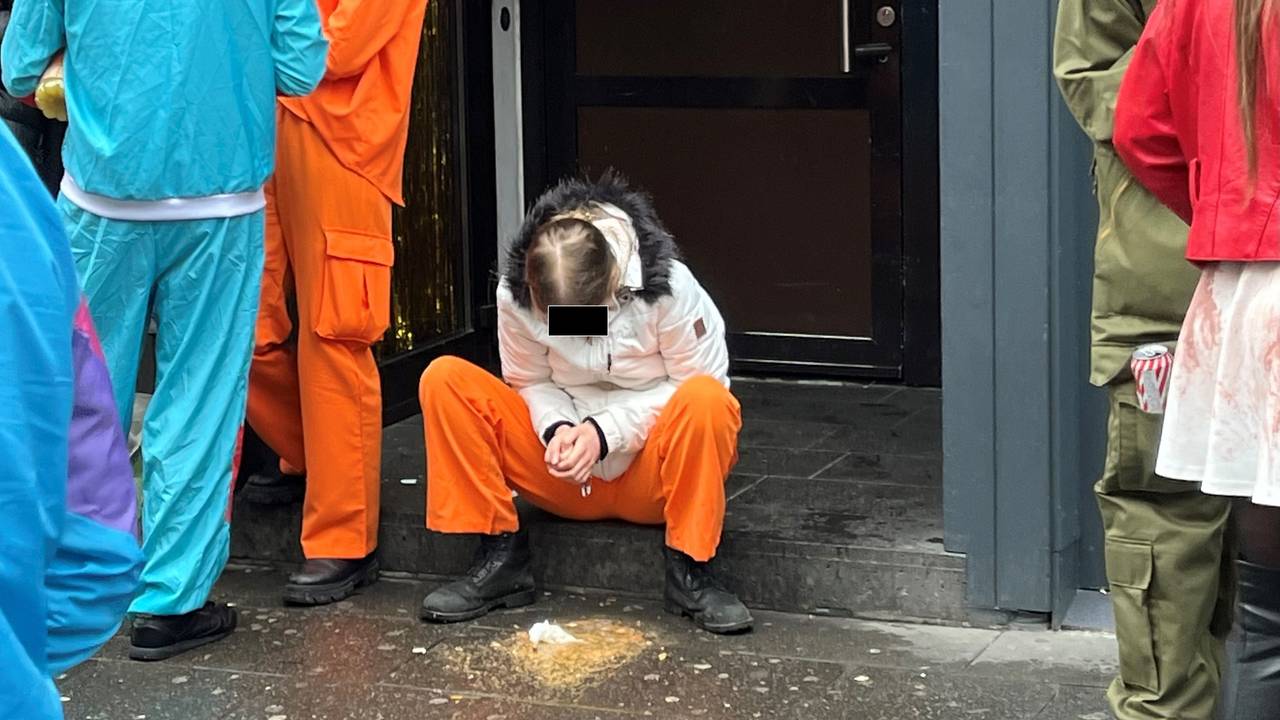 Eine junge Person sitzt auf der Stufe eines Hauseingangs und hat sich erbrochen.
