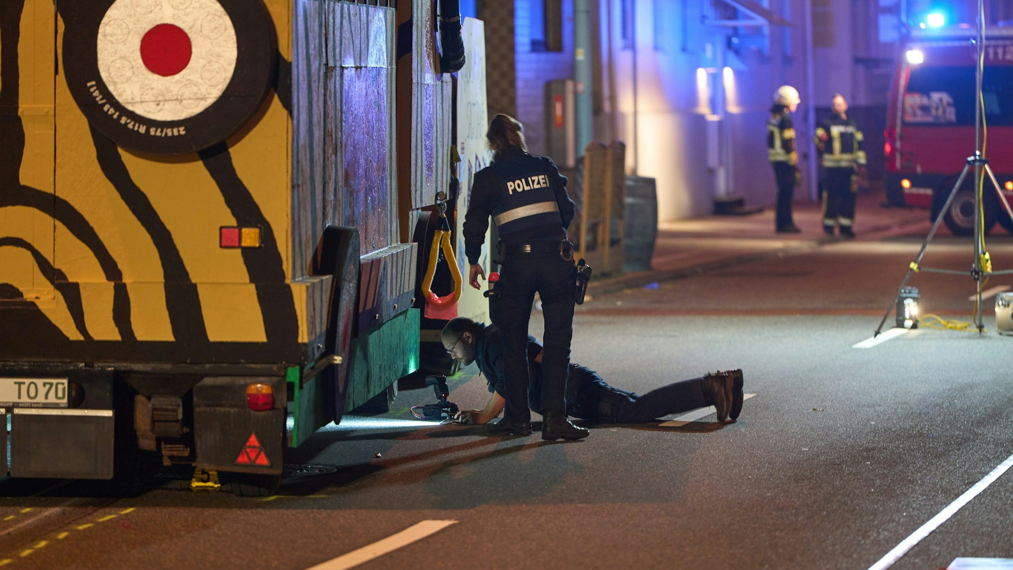 Polizeibeamte sichern Spuren an einem Karnevalswagen, nachdem ein Fußgänger überrollt worden war.