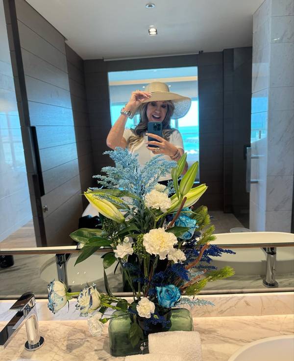 Carmen Geiss steht vor einem Spiegel und macht ein Selfie. Sie trägt einen Hut und lächelt.