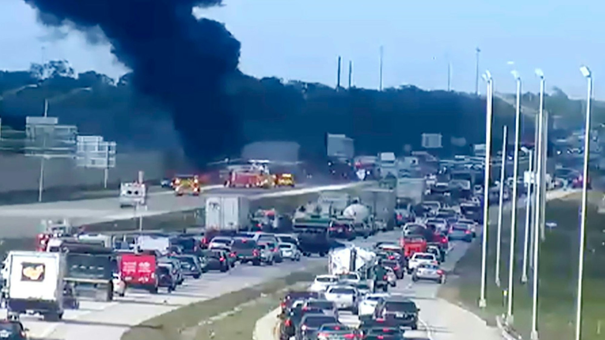 In this image provided by the Florida Department of Transportation, Florida Highway Patrol troopers are on the scene of a small airplane landing on southbound Interstate 75 in Naples, Fla., Friday, Feb. 9, 2024. The plane collided with a vehicle as it made the emergency landing. (Florida DOT/The News-Press via AP)