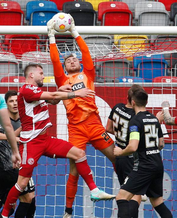Der Düsseldorfer Andre Hoffmann und der Elversberger Keeper Nicolas Kristof kämpfen um den Ball.