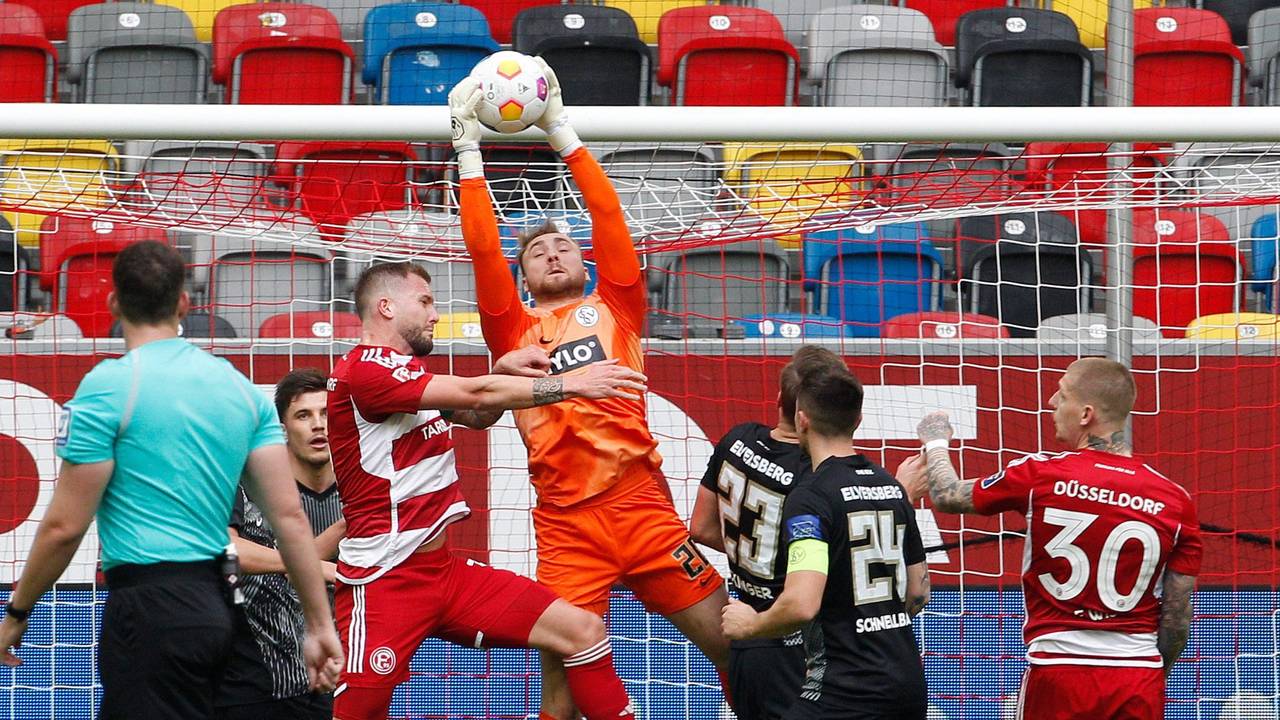 Der Düsseldorfer Andre Hoffmann und der Elversberger Keeper Nicolas Kristof kämpfen um den Ball.