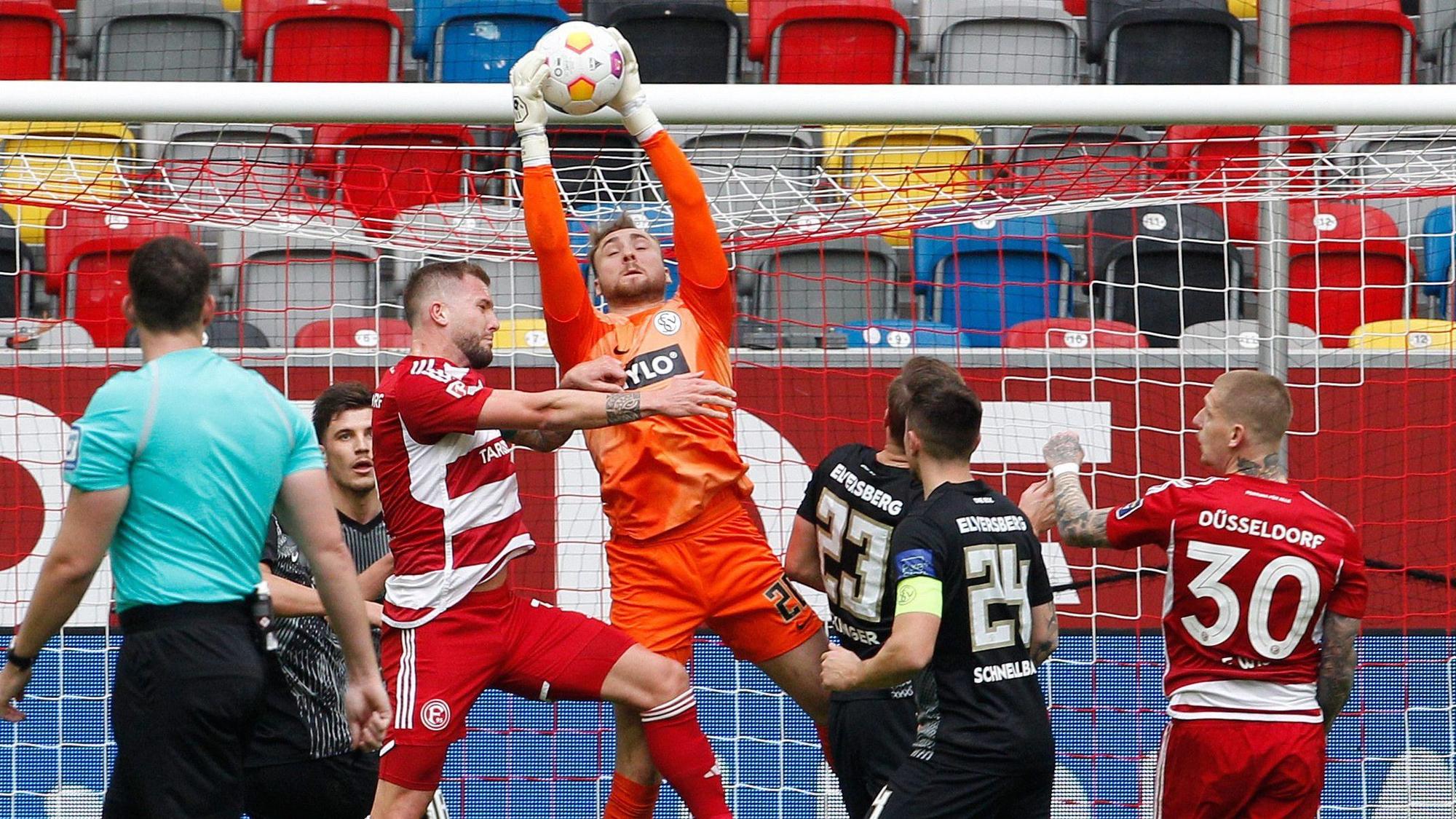 Der Düsseldorfer Andre Hoffmann und der Elversberger Keeper Nicolas Kristof kämpfen um den Ball.