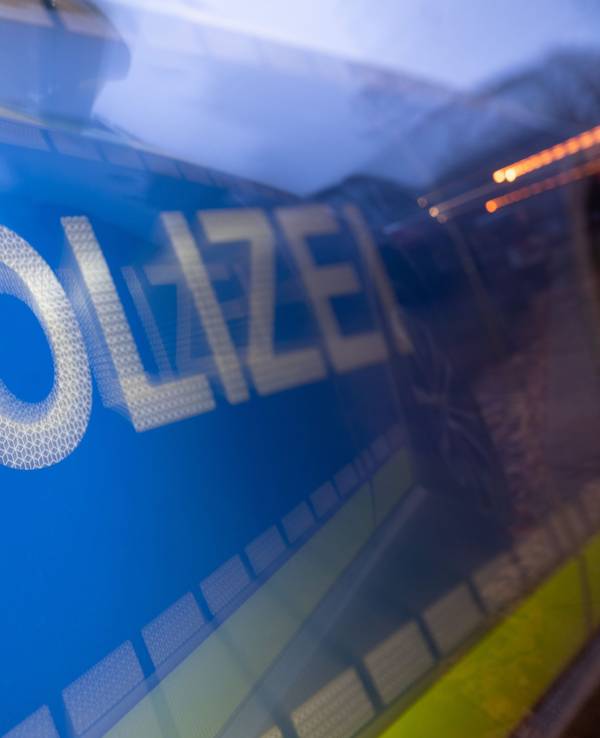 Das Wort Polizei ist im Rahmen eines Fototermins auf der Karosserie eines Polizeifahrzeugs zu sehen (gestellte Szene, Wischeffekt durch Langzeitbelichtung).