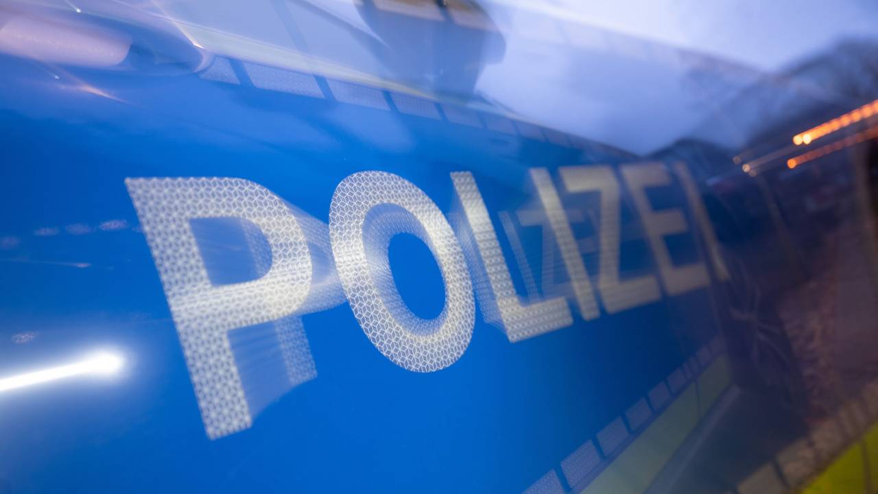 Das Wort Polizei ist im Rahmen eines Fototermins auf der Karosserie eines Polizeifahrzeugs zu sehen (gestellte Szene, Wischeffekt durch Langzeitbelichtung).