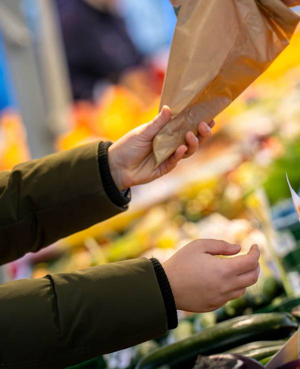 An einem Marktstand wird mit Bargeld eingekauft