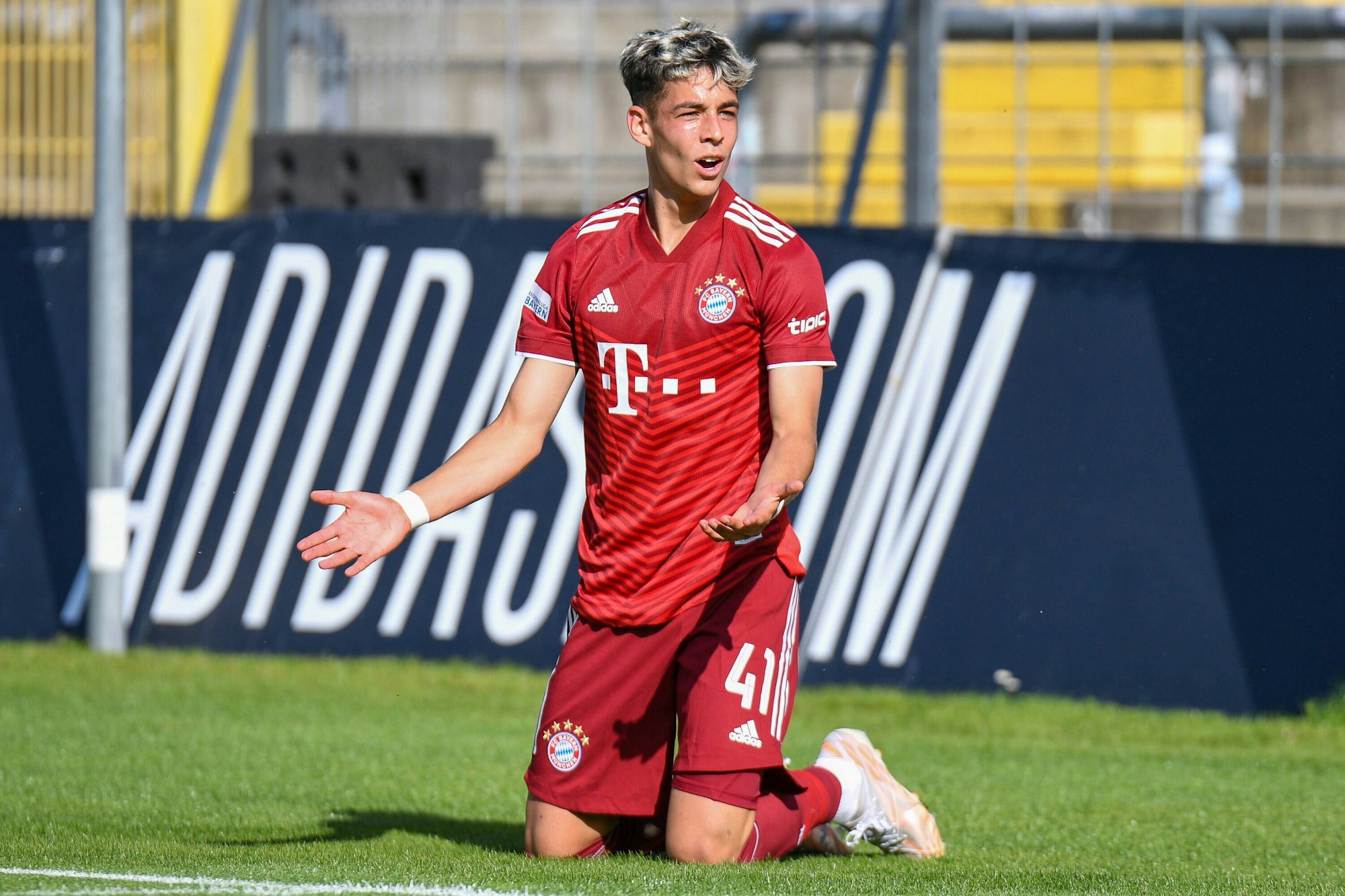 Nick Salihamidzic kniet im Bayern-Trikot auf dem Rasen.