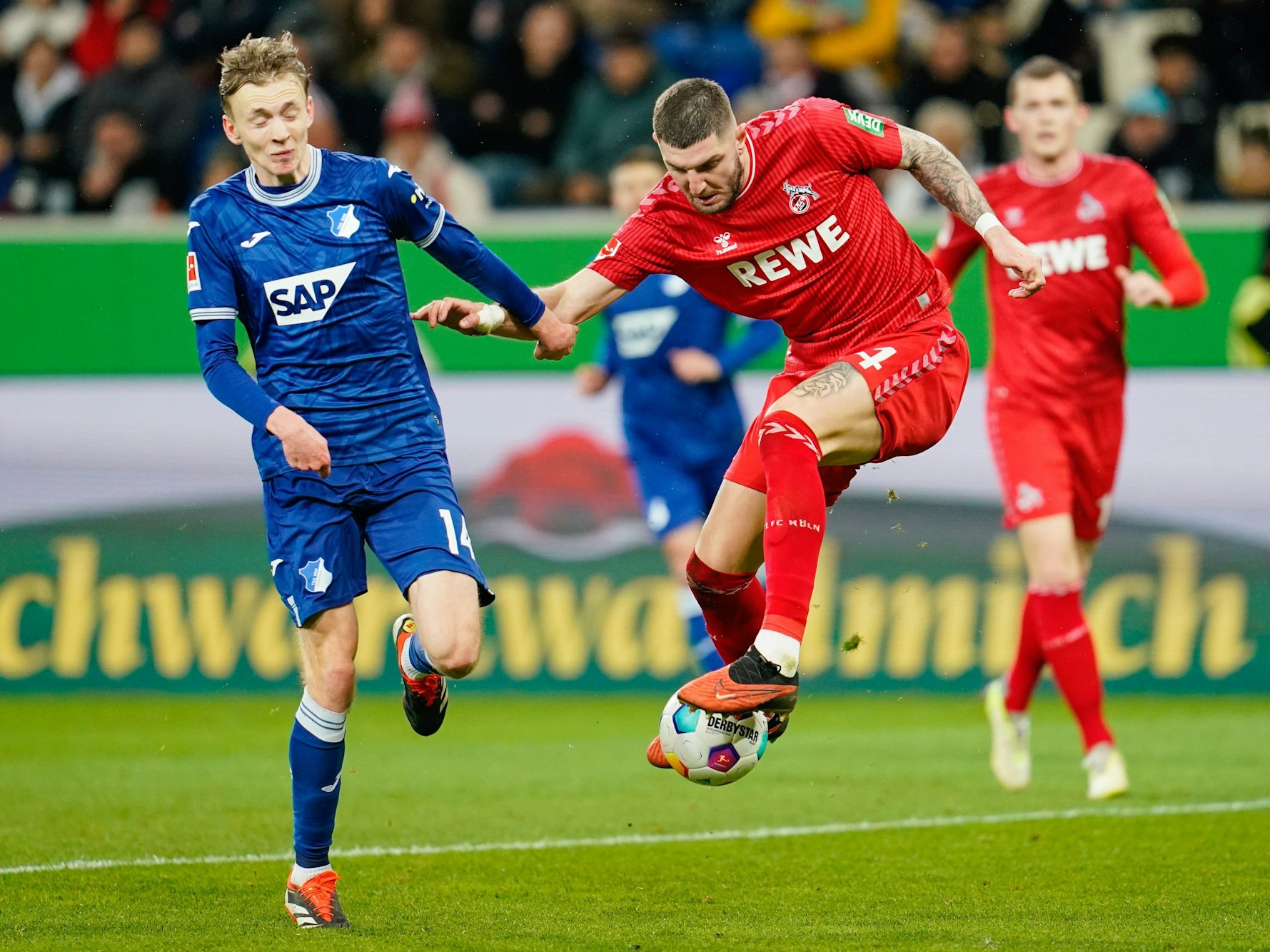Hoffenheims Maximilian Beier (l) und Kölns Julian Chabot kämpfen um den Ball.