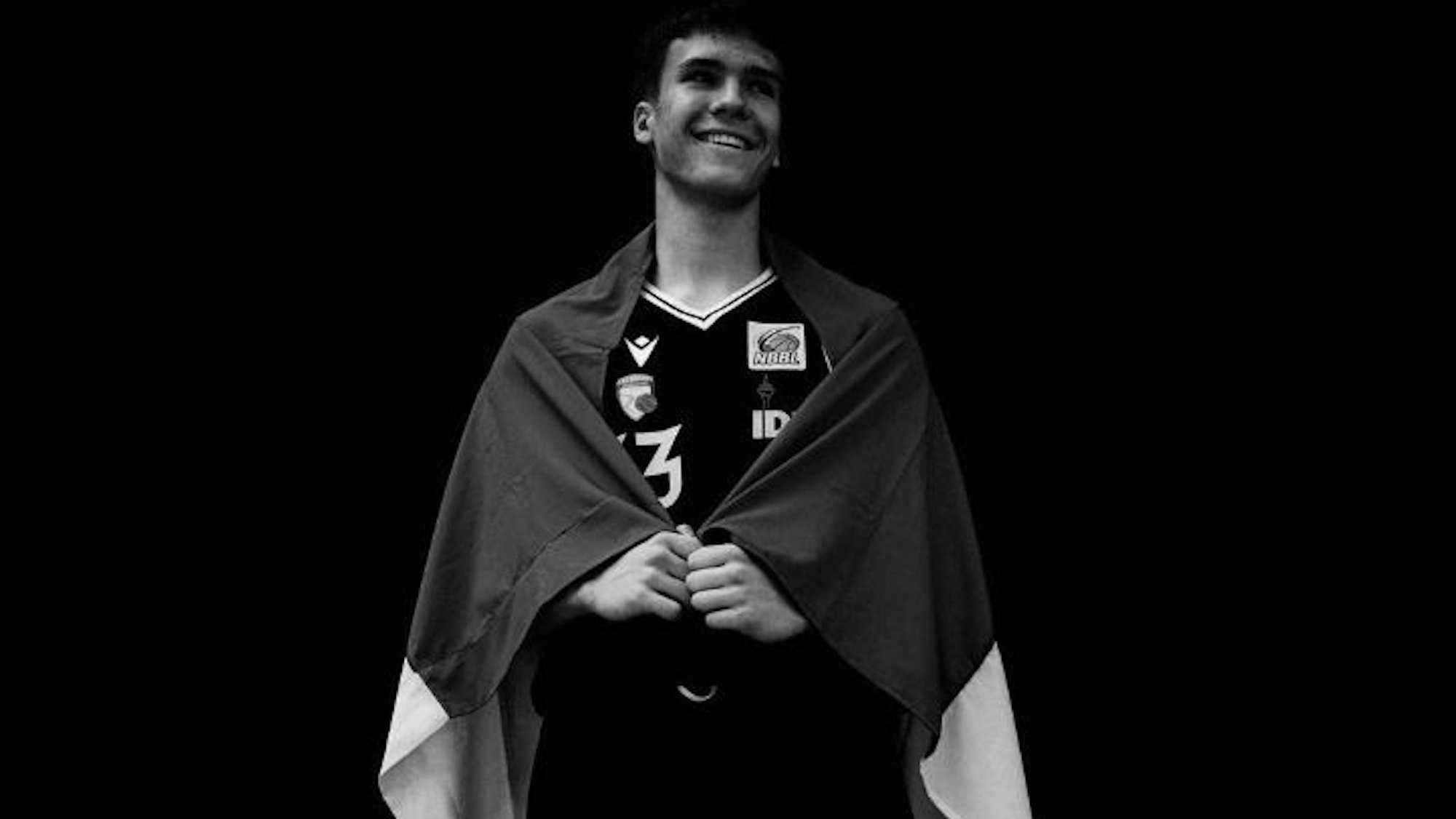 Schwarz-Weiß-Foto von Volodymyr Yermakov mit Ukraine-Flagge um die Schultern.